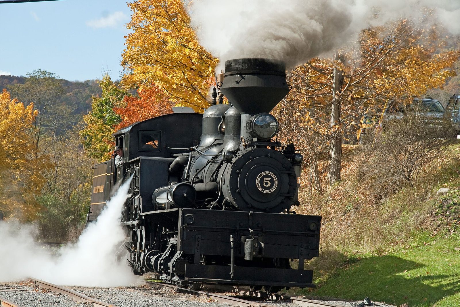 A Cass Scenic Railroad steam locomotive at the station, with yellow and orange maples behind it.